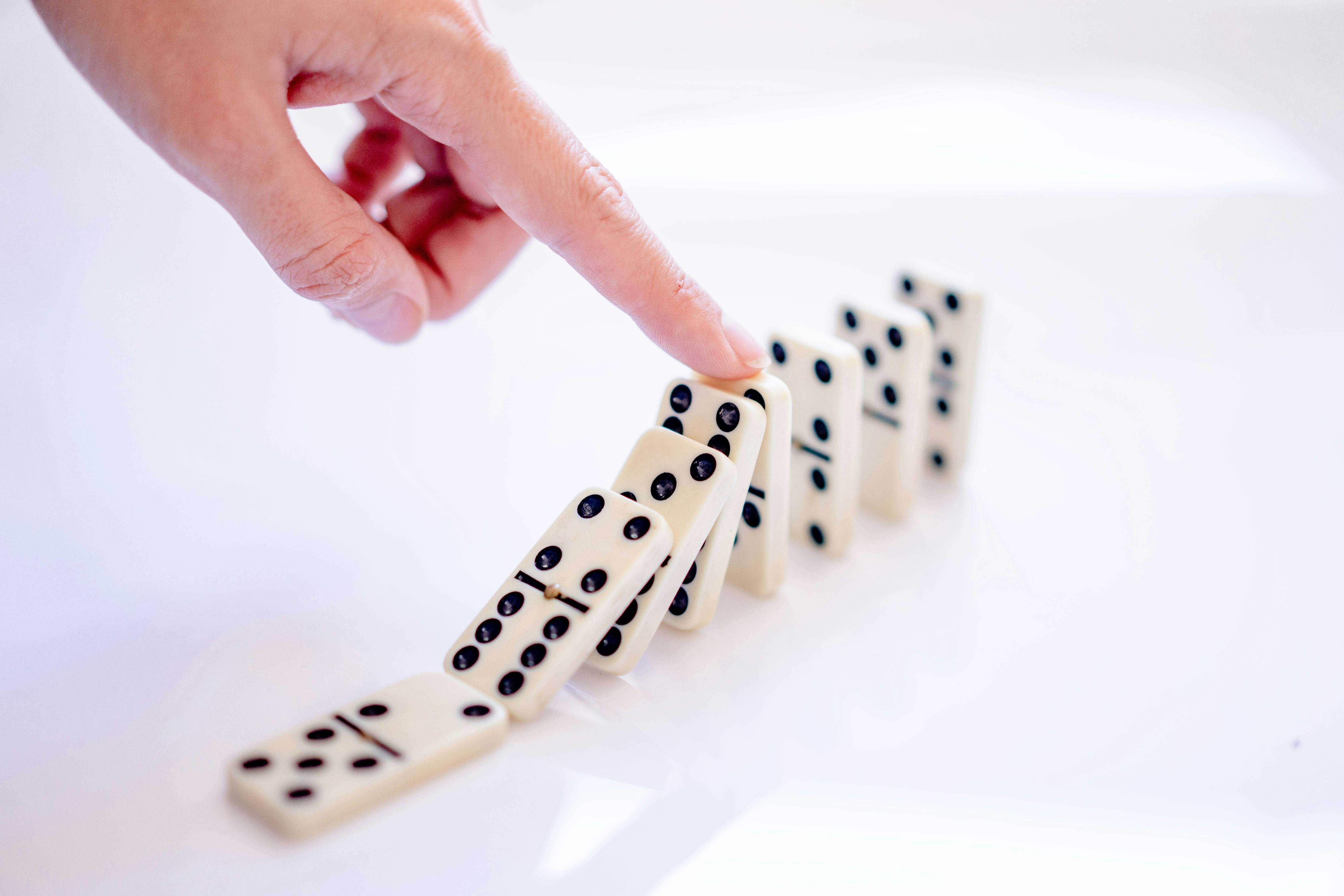 A falling domino chain stopped by hand